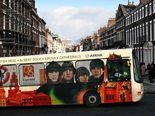 Ein Bus in Liverpool mit einem Foto der Beatles. © Clipdealer / Illu