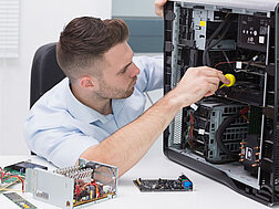 Ein Techniker schraubt an einem Computergehäuse