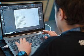 Jugendlicher tippt auf Laptop auf dessen Bildschirm "Demokratie Erklärung" steht