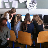 Fünf Schülerinnen schauen auf ihren gemeinsamen Monitor.