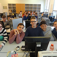 Schüler und Schülerinnen vor ihren gemeinsamen Computern.