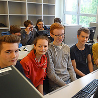 Schüler und Schülerinnen vor ihren gemeinsamen Computern.