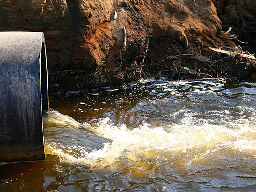 Ein Wasserabflussrohr verschmutz den Fluss