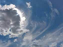 Die Sonne verbirgt sich hinter einer Wolke auf einem bewölkten Himmel.
